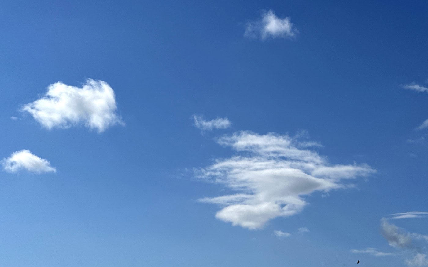 a few small white cumulus clouds against a blue sky