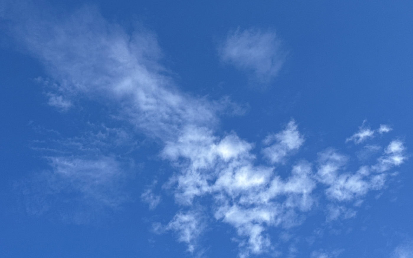 small altocumulus clouds with a patch of cirrus cloud above