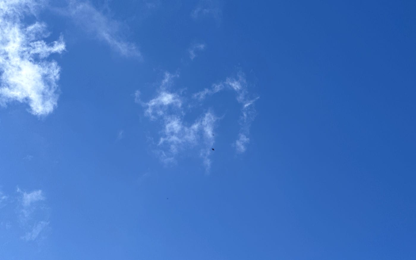 a clear blue sky with just a few whisps of thin cloud