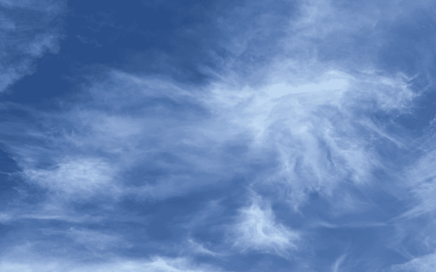 streaks of high white cirrus clouds against a blue sky